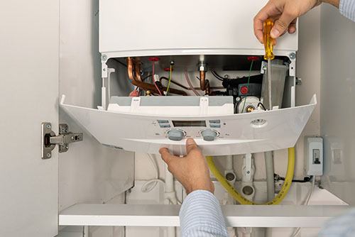 Heating technician repairing a residential boiler in Glendale