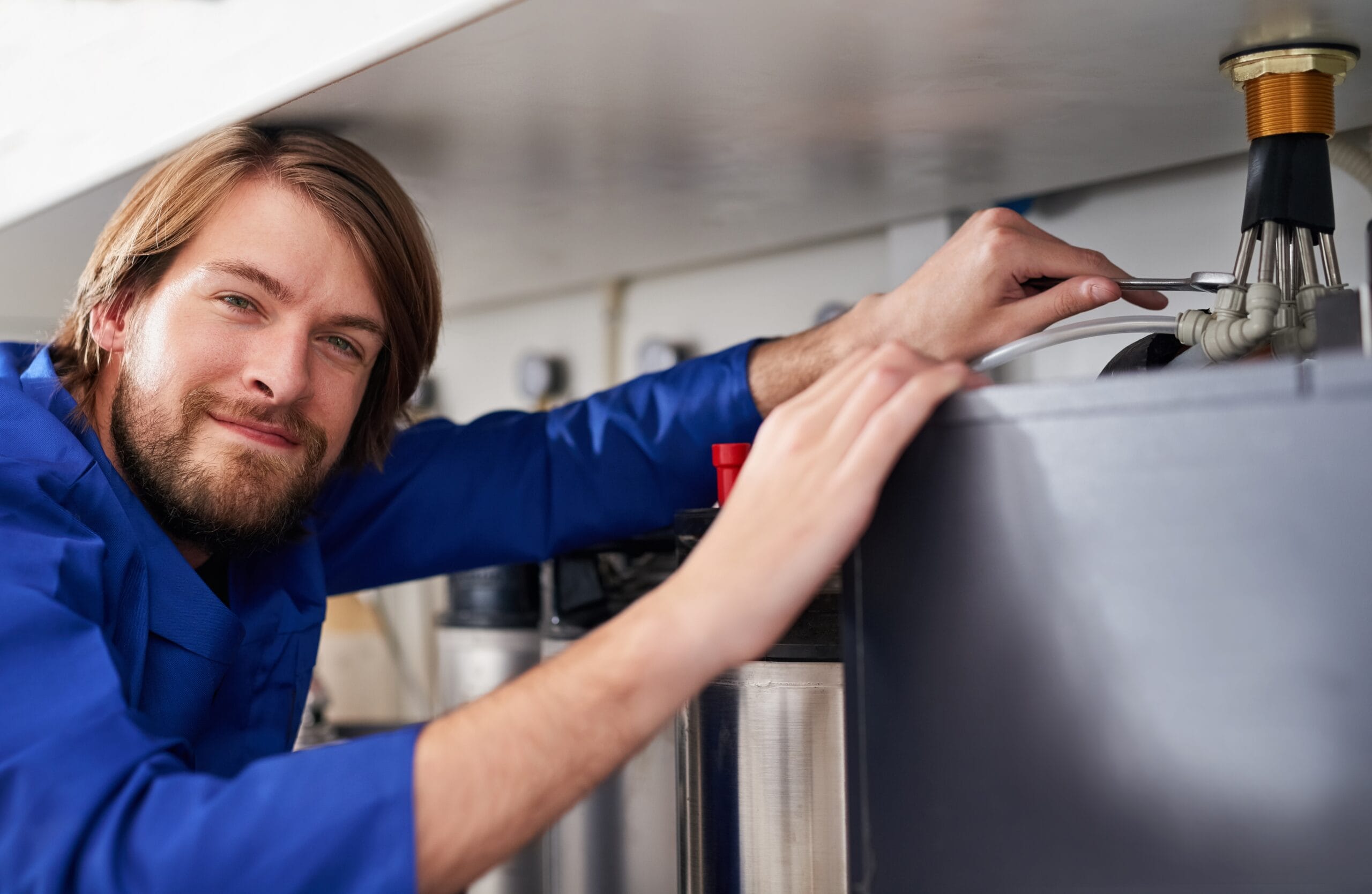 Technician servicing a residential water heater tank in Glendale